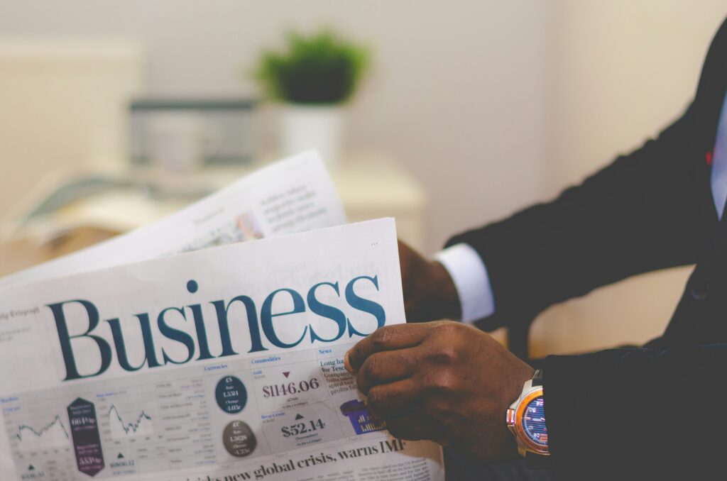 「読む力」は、実践と反復から生まれる スーツ姿の男性が「Business」と書かれた英字新聞を読む様子