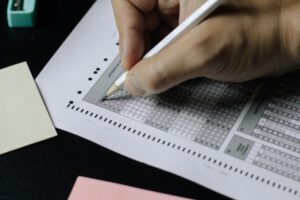 マークシートに鉛筆で解答する手元の写真。TOEICなどの試験を連想させるイメージ。