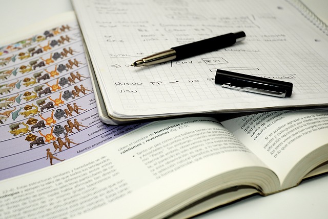 TOEIC Part5を攻略するための積み重ね学習と実践ノート 開いた参考書とノートに学習内容を書き込んだ机上の風景。ペンが添えられ、英語学習の積み重ねを象徴する。