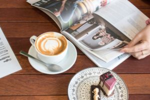 カフェでコーヒーを飲みながら英文ニュースや雑誌を読む様子