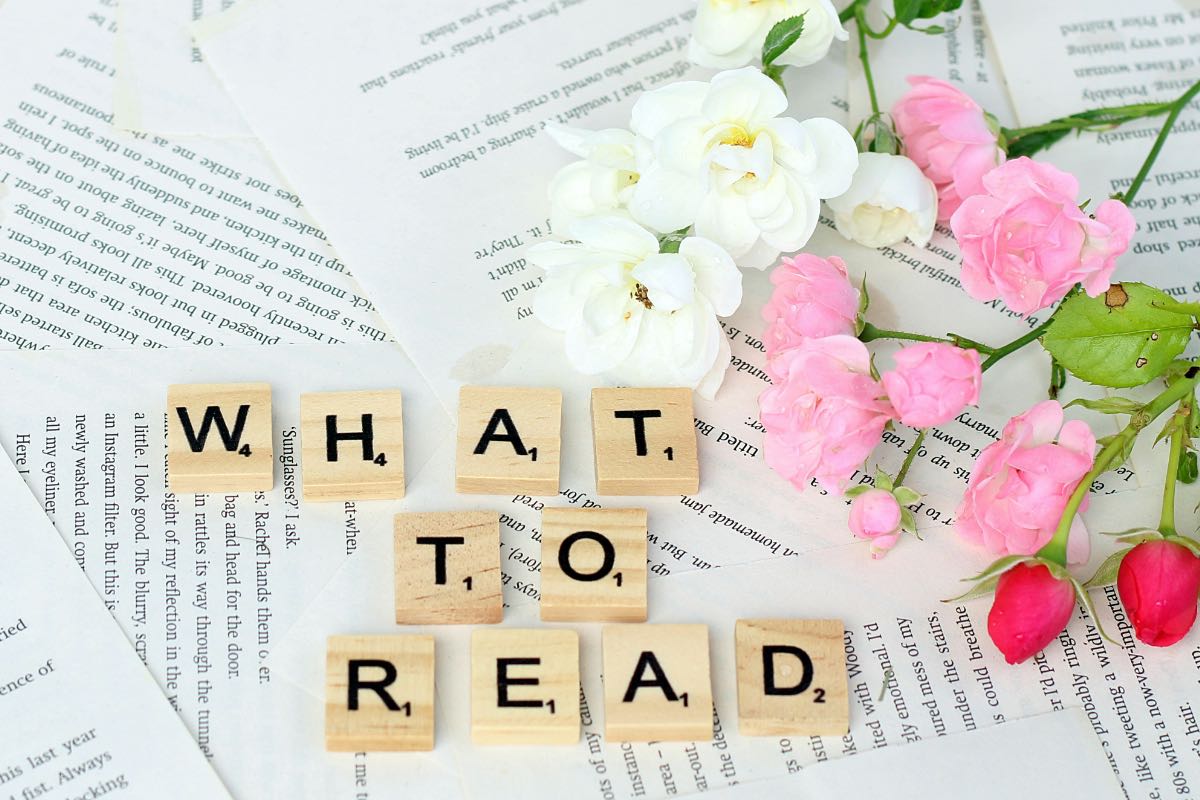 英文テキストと花、スクラブルの文字が並ぶ読書イメージ。英語学習で“何を読むか・どう読むか”を考える象徴的な構図。