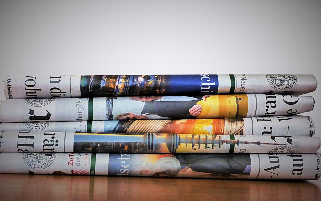 積み重ねられた新聞を使って英文ニュースを精読するイメージ