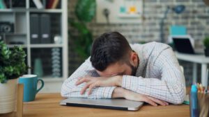 英語学習のスランプで机に突っ伏している男性のイメージ