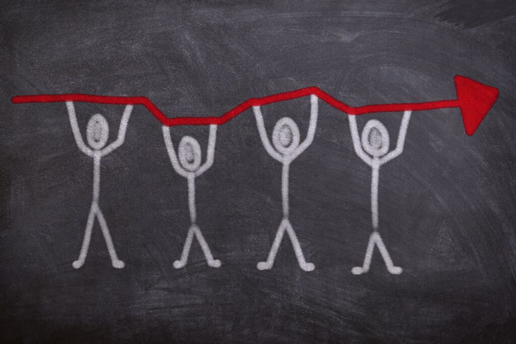 黒板に描かれた人物たちが上昇する矢印を支えているイラスト｜語彙が"使える"に成長するイメージ