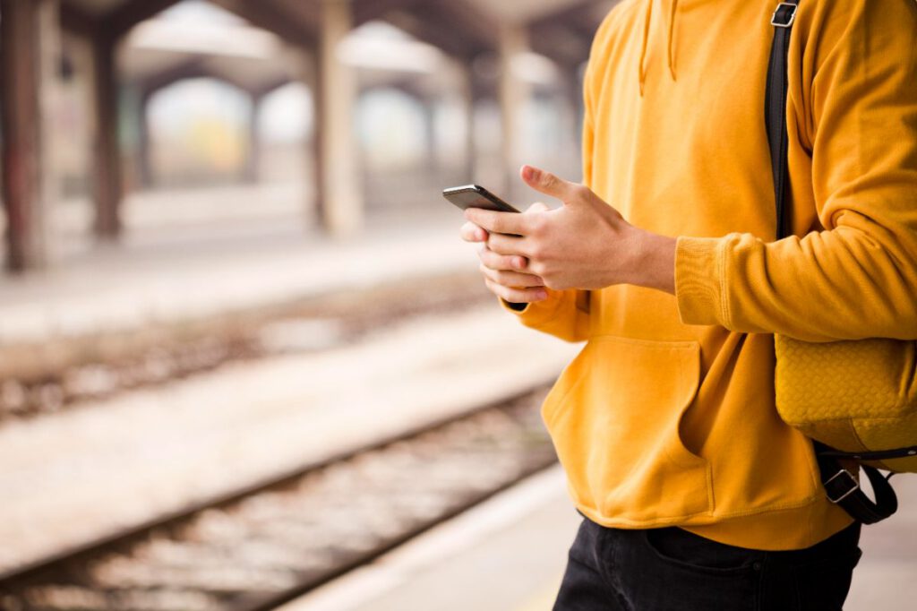 駅のホームでスマホを操作する人物｜英語学習の優先度を考えるイメージ