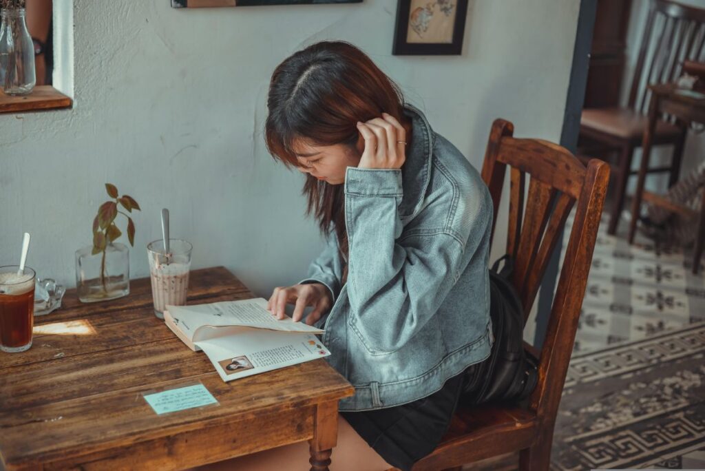 カフェで英文記事を集中して読み込む女性、精読に取り組む様子