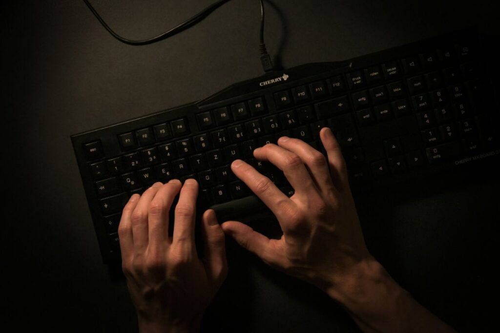 暗闇の中キーボードを打つ手元|深夜までAIと向き合うトビーのリアル