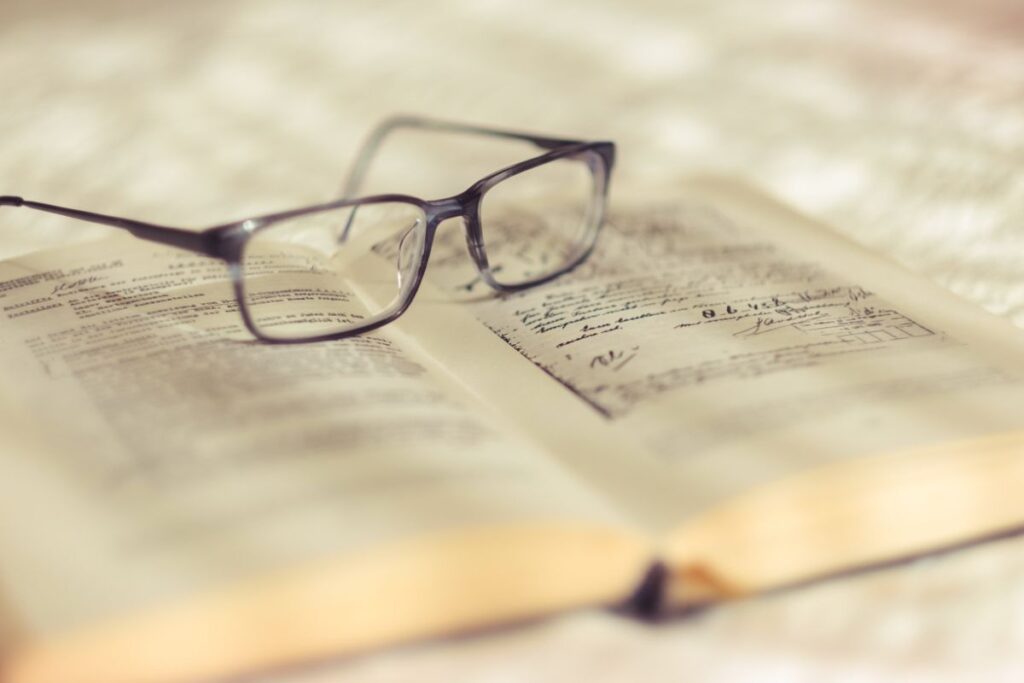 書き込みのある本と眼鏡、精読のイメージ
