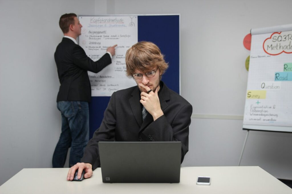 オフィスでノートPCを前に考え込む男性会社員