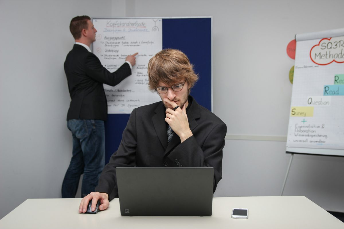 オフィスでノートPCを前に考え込む男性会社員